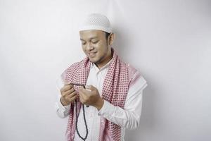 Lycklig stilig asiatisk muslim man är bön- till Gud. foto