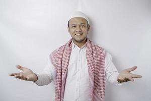 ung asiatisk muslim man presenter ett aning medan leende på isolerat vit bakgrund foto