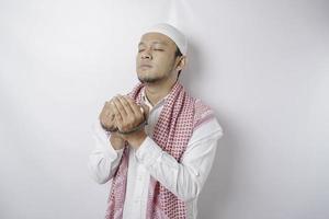 Lycklig stilig asiatisk muslim man är bön- till Gud. foto