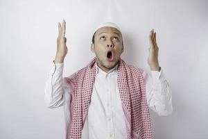 chockade asiatisk muslim man pekande på de kopia Plats på topp av honom, isolerat förbi en vit bakgrund foto