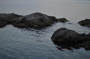 stenar på de strand, lugna vatten foto