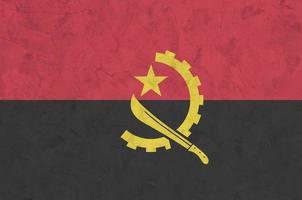 angola flagga avbildad i ljus måla färger på gammal lättnad putsning vägg. texturerad baner på grov bakgrund foto