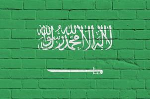 saudi arabien flagga avbildad i måla färger på gammal tegel vägg. texturerad baner på stor tegel vägg murverk bakgrund foto