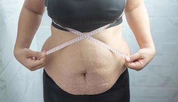 fet kvinna behov vikt kontrollera, hon har överskott fett. foto