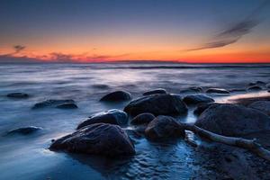 stenar på de kust av de baltic hav på solnedgång foto