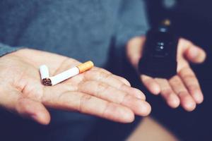 man sluta rökning. begrepp jämförelse val i händer mellan tobak cigarett och elektronisk cigarett. foto