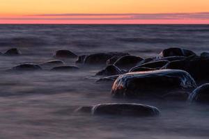 stenar på de kust av de baltic hav på solnedgång foto