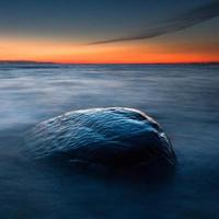 stenar på de kust av de baltic hav på solnedgång foto