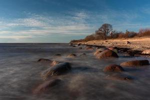 stenar på de kust av de baltic hav på solnedgång foto