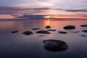 stenar på de kust av de baltic hav på solnedgång foto