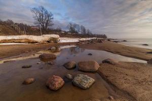 stenar på de kust av de baltic hav på solnedgång foto