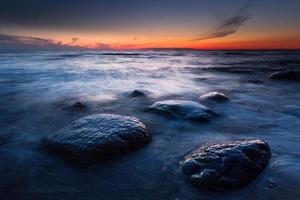 stenar på de kust av de baltic hav på solnedgång foto