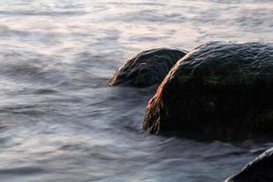 stenar på de kust av de baltic hav på solnedgång foto