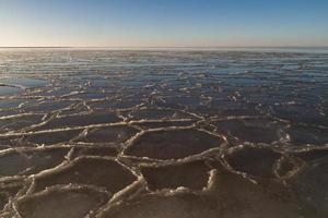 baltic hav kust med småsten och is på solnedgång foto