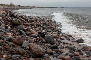 baltic hav kust med småsten och is på solnedgång foto