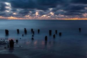 baltic hav kust med småsten och is på solnedgång foto