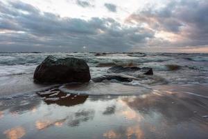 baltic hav kust med småsten och is på solnedgång foto