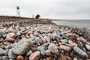 baltic hav kust med småsten och is på solnedgång foto