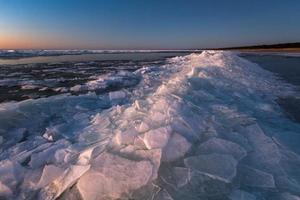 baltic hav kust med småsten och is på solnedgång foto