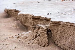 baltic hav kust med småsten och is på solnedgång foto