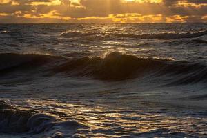 baltic hav kust med småsten och is på solnedgång foto