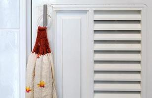 närbild av de tyg hand handduk är hängande nära de vit dörr. foto