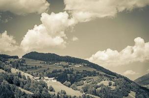underbar trädbevuxen berg alpina panorama med by och hyddor Österrike. foto