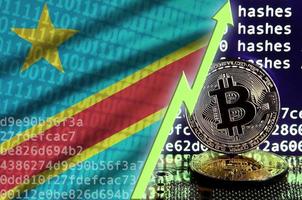 demokratisk republik av de kongo flagga och stigande grön pil på bitcoin brytning skärm och två fysisk gyllene bitcoins foto