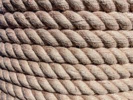 textur, bakgrund. en stark, fast rep är sår på en rulle. snöre för bindande tillverkad av hållbar brun material. trådar är drog från de rep foto