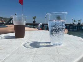 trä- tabell med glasögon av uppfriskande citron- dryck på varm sommar dag utomhus, Plats för text foto