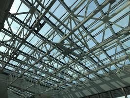 de glas tak av de modern byggnad stöder en stål balkar rutnät foto