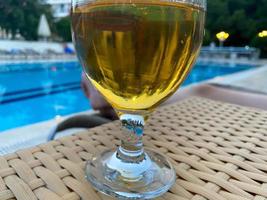 enkel halvliter glas av kall lageröl öl Sammanträde på kant av blå simning slå samman foto