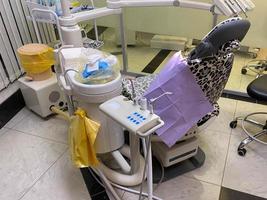 stomatologi interiör av små dental klinik med professionell stol i grön färger. tandvård, medicin, medicinsk Utrustning foto
