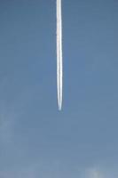 vit vakna av ett flygplan under de blå himmel foto