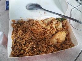 där är fortfarande en massa av överbliven friterad ris i en papper låda behållare. foto