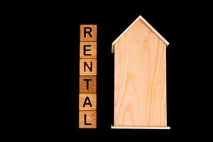 trä- hus attrapp med hus nycklar, trä- kuber med ord hyra försäljning , köpa och lån. på svart bakgrund foto