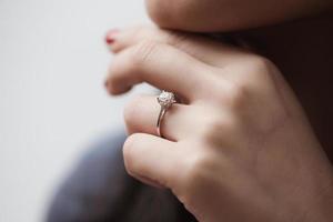 stänga upp av ett elegant engagemang diamant ringa på kvinna finger foto