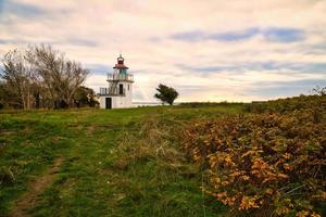 fyr, spodsbjerg fyr i jagade på de kust av Danmark. Sol strålar lysande foto