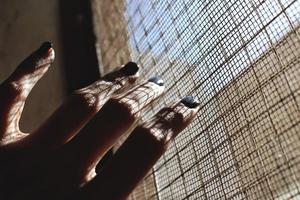 närbild av kvinnas hand med målad naglar i solljus foto