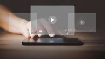 man använder sig av en smartphone eller mobil telefon för strömning uppkopplad på virtuell skärm, sökande video på internet, leva fotboll, visa eller handledning, tittar på de filmer, innehåll uppkopplad. foto