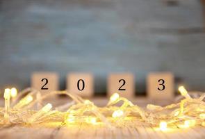 suddig Lycklig ny år 2023 på trä tabell och fläck abstrakt bokeh ljus foto