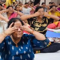 New Delhi, Indien, 19 juni 2022 - gruppyoga träningspass för människor i olika åldersgrupper i balajitemplet, vivek vihar, internationella yogadagen, stor grupp vuxna som deltar i yogaklass i templet foto