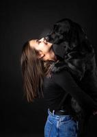 en flicka håller en labrador retrieverhund i famnen. foto