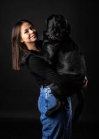 en flicka håller en labrador retrieverhund i famnen. foto