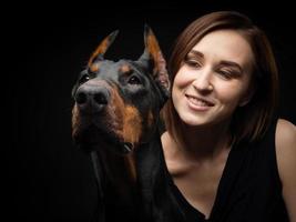porträtt av en doberman hund med en flicka ägare. foto