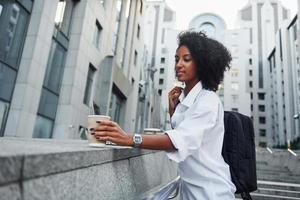afrikansk amerikan kvinna i Bra kläder är utomhus i de stad på dagtid foto