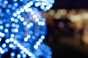 närbild och beskära med suddig och bokeh dekorerad led av jul blå belysning i snöflinga form på suddigt bakgrund. foto