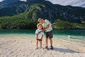 bror med syster och hund mot sjö bohinj, de största sjö i Slovenien, del av triglav nationell parkera. foto