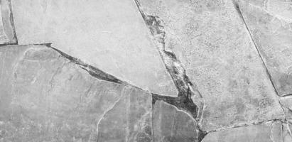grå betong bakgrund. grå knäckt cement vägg eller marmor tapet i årgång tona. linje mönster på granit golv. foto
