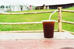 americano kaffe på trä tabell med berg kulle se bakgrund foto